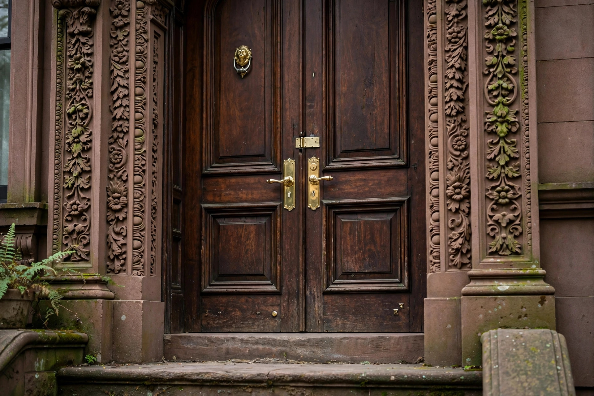 Ornate brownstone entrance with brass door hardware in Carroll Gardens